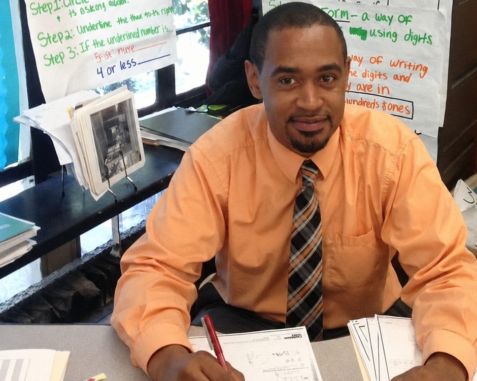 Hakim Rashad seated at his classroom desk during his first year as a math teacher.